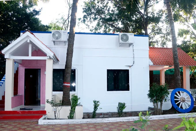 Standalone cottage-style guest building with white exterior and red roof