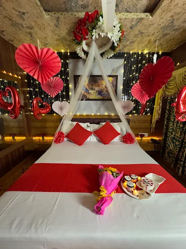 Romantically decorated guest room with red and white bedding and warm lights